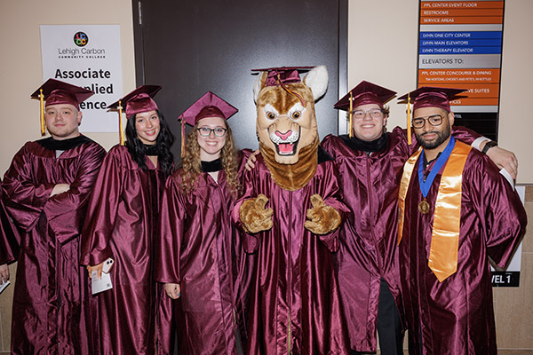 Students at graduation with LCCC mascot clawrence