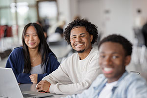 Male and female students smiling in cafe