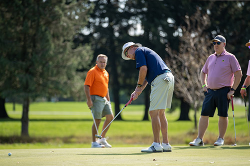 Men putting on golf course